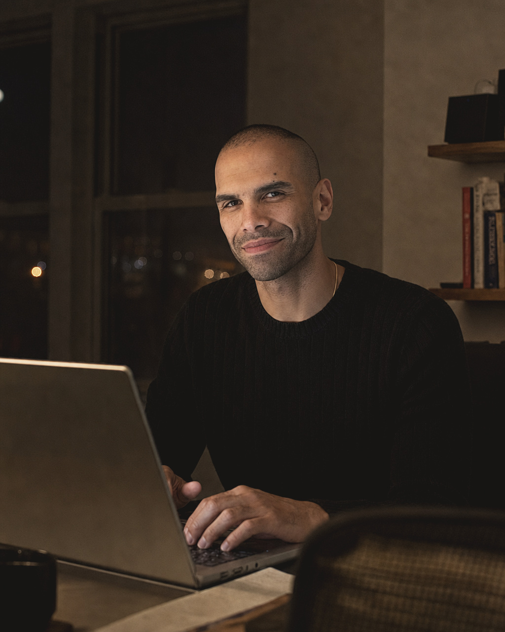 Daniel Nakhla at his laptop, lit by the screen in the dark